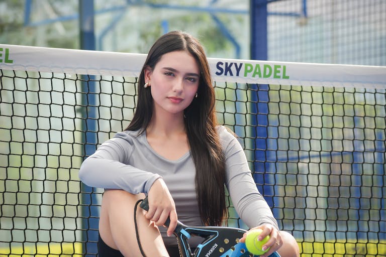vrouw op de padelbaan met padel kleding aan
